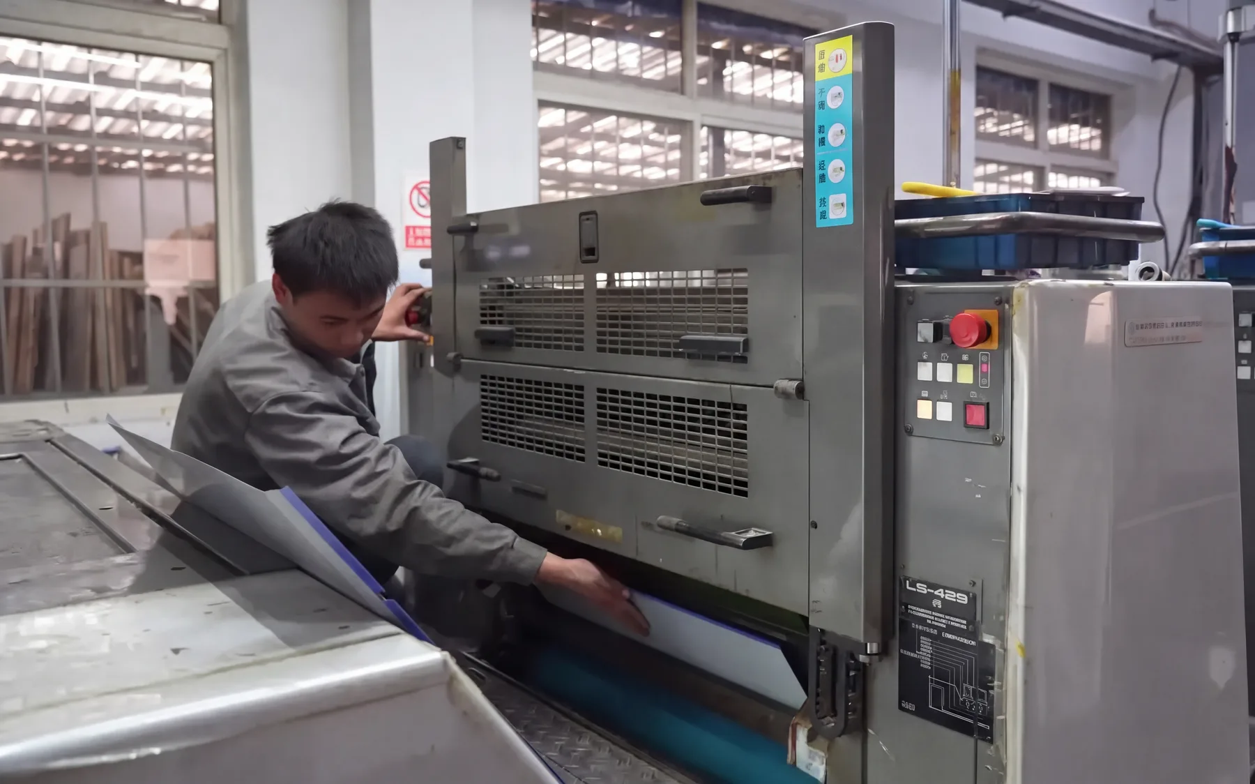 Worker operating printing equipment in Hengfor Packaging factory
